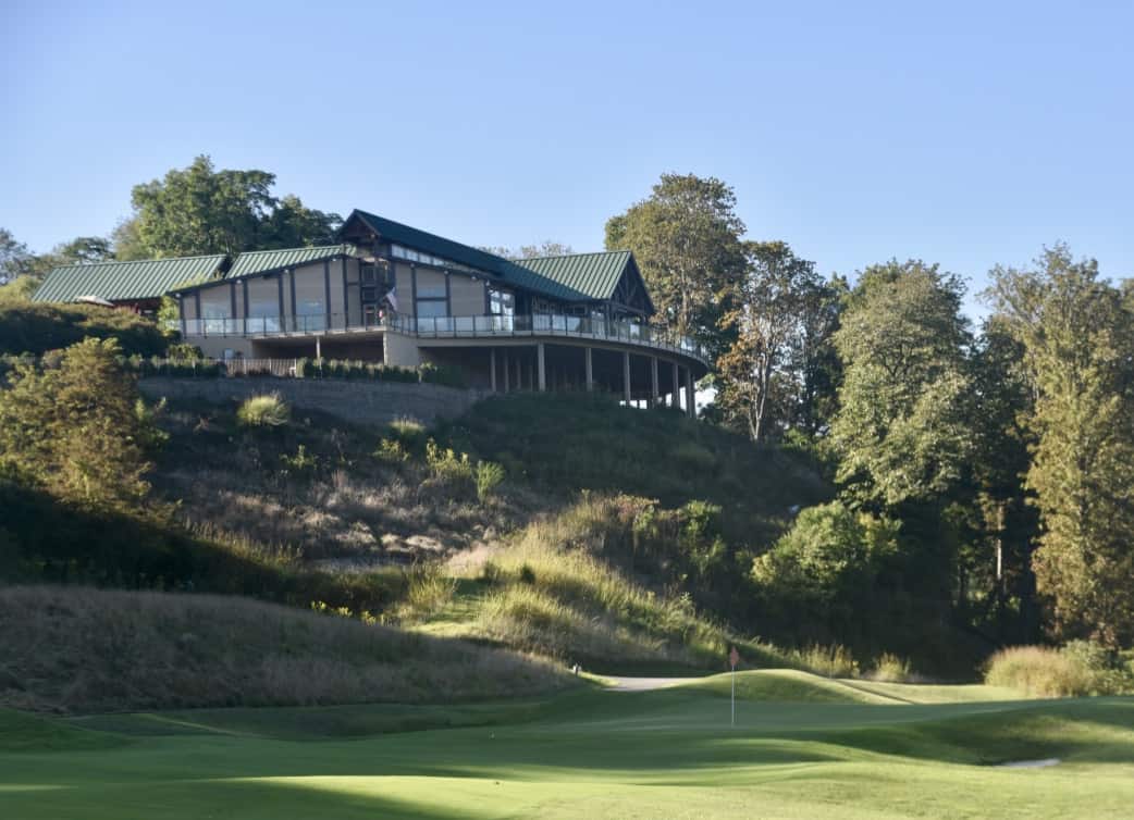 The eighteenth hole at the Pete Dye River Course with the clubhouse behind