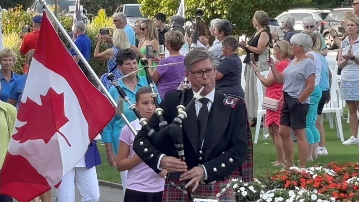 The bagpiper leading the teams