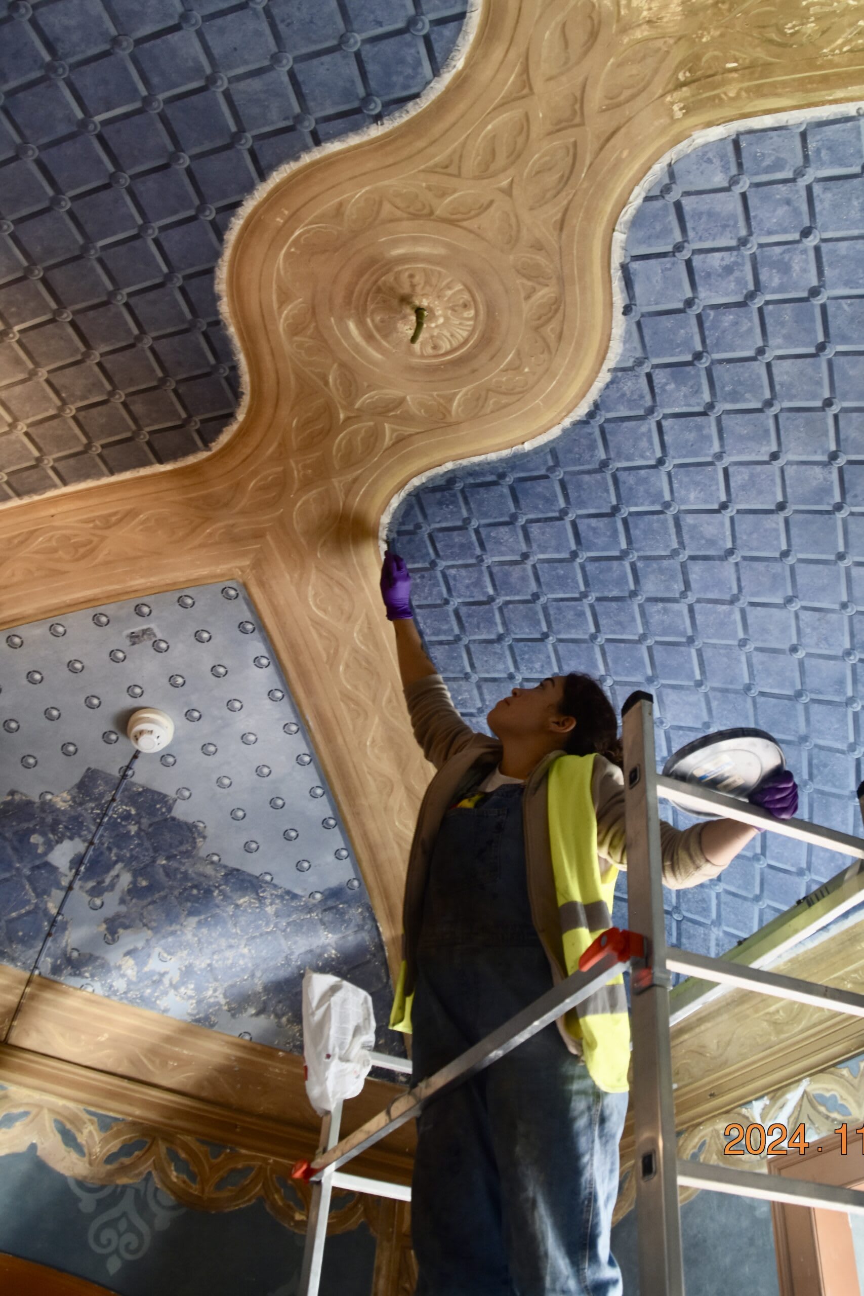 Restoring a ceiling fresco inside the palace