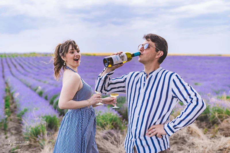 Ζευγάρι με φόντο λεβάντα να πίνουν κρασί