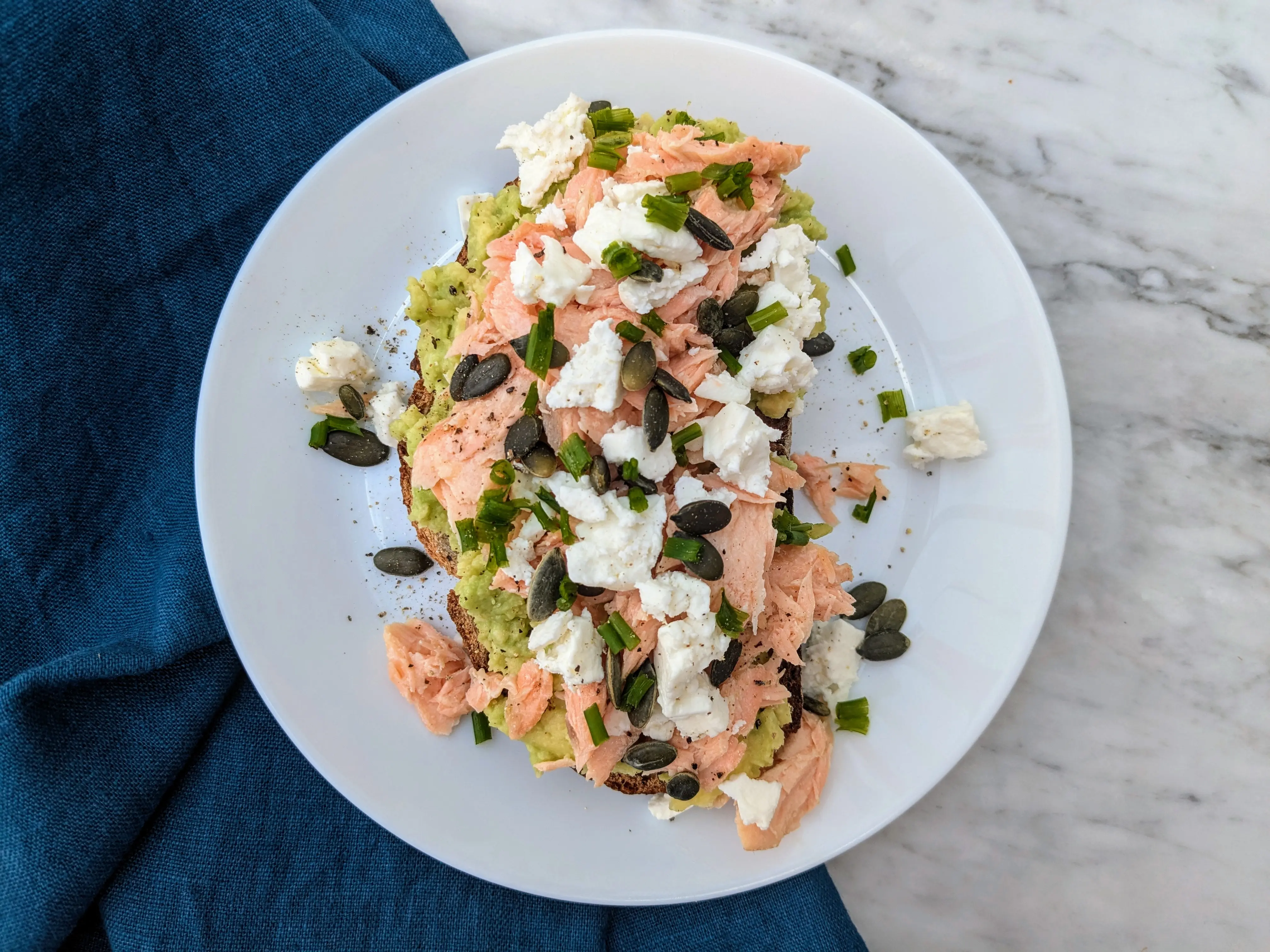 Avocado on toast with cooked salmon and feta cheese