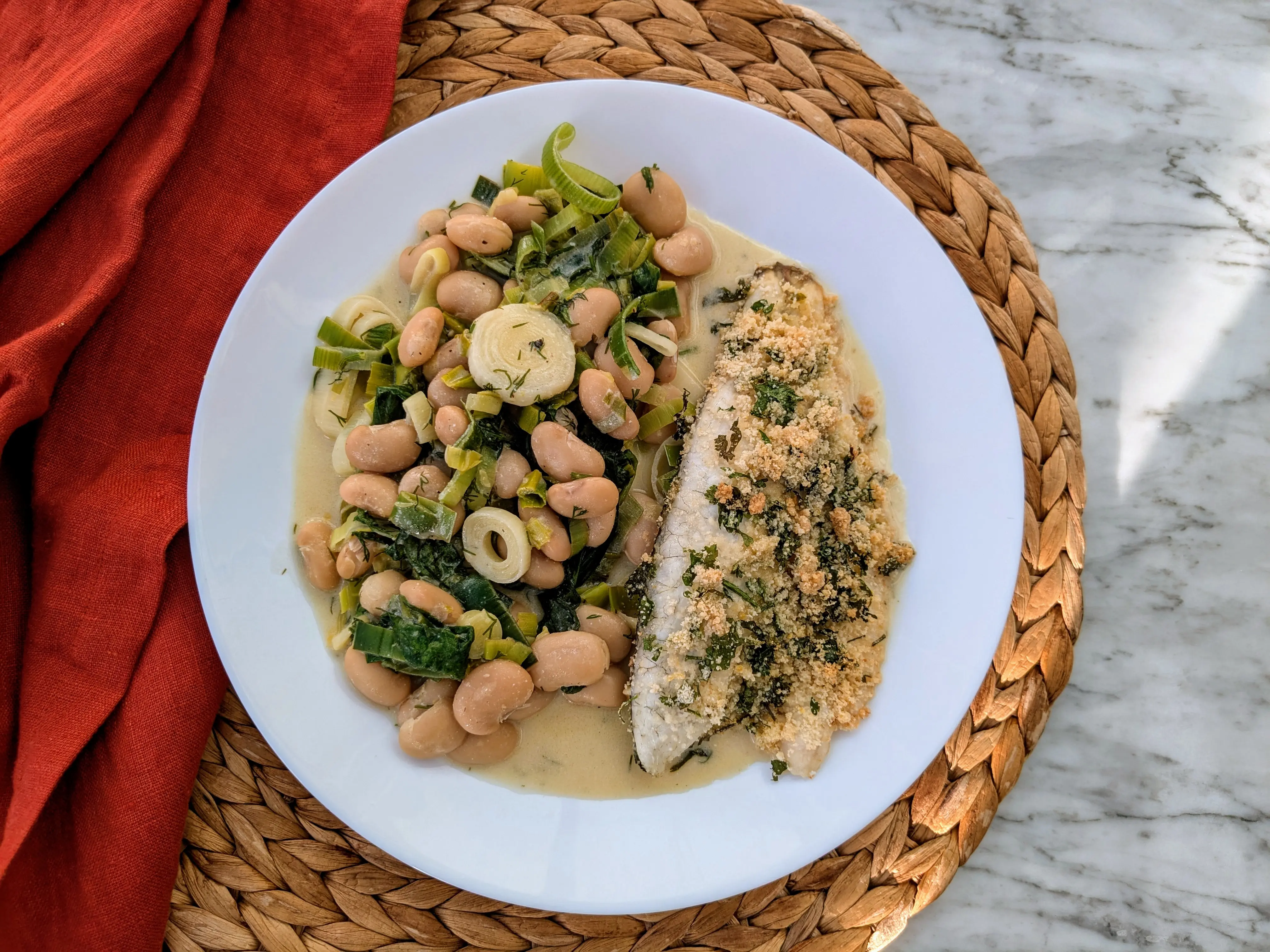 Crusty sea bass with creamy leeks and herby butter beans