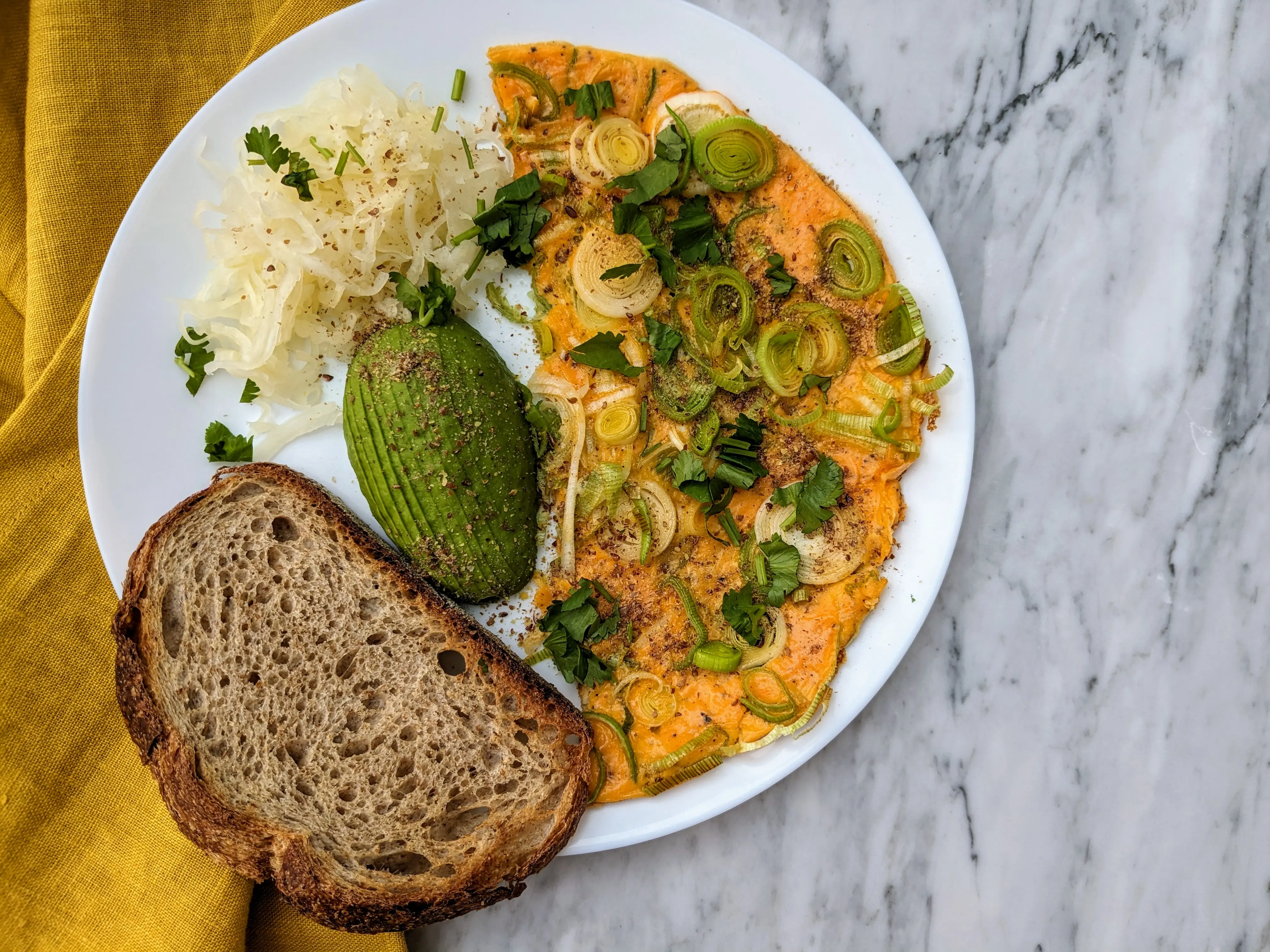 Leek omelette served with avocado and sourdough bread