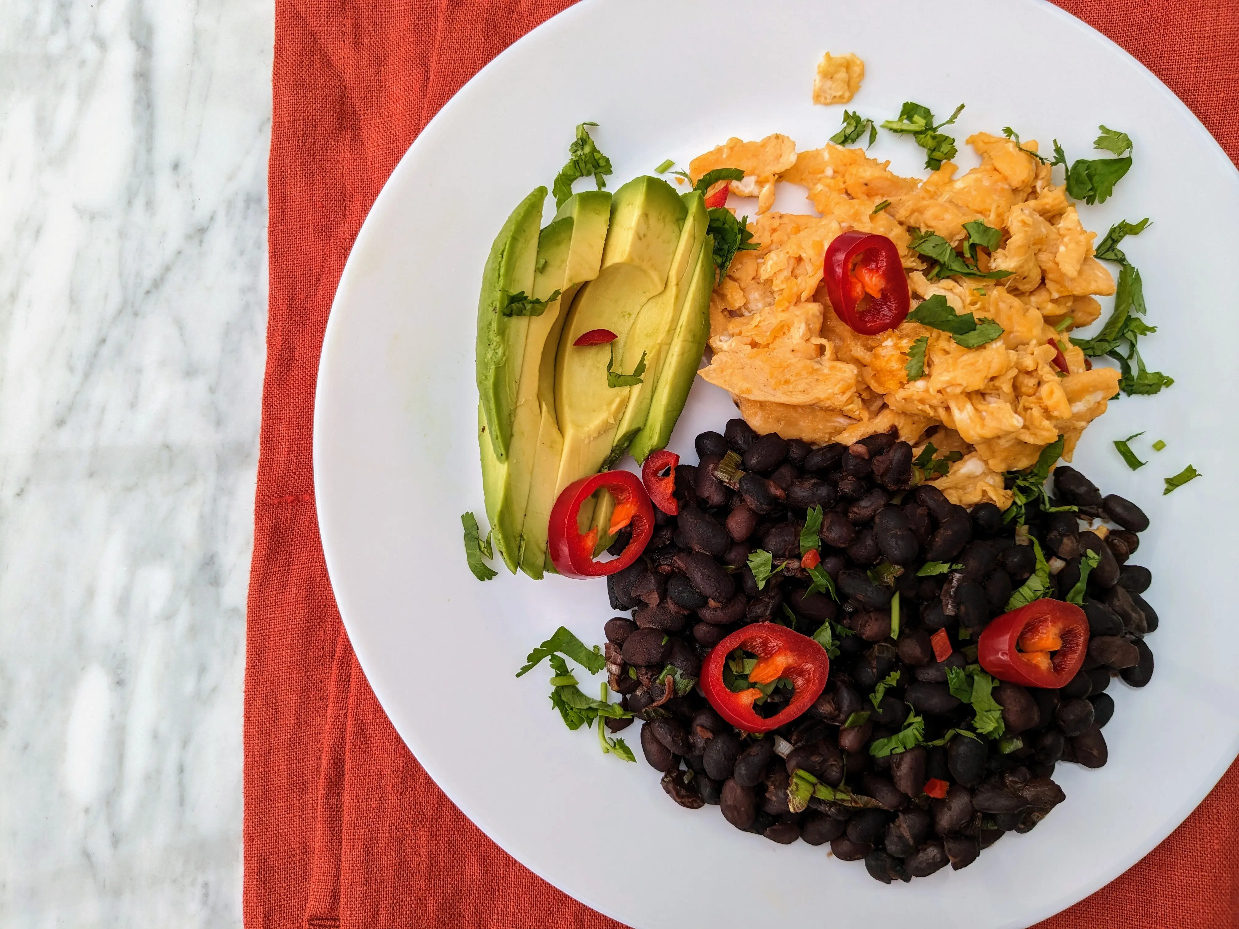 Mexican style scrambled eggs with black beans and avocado