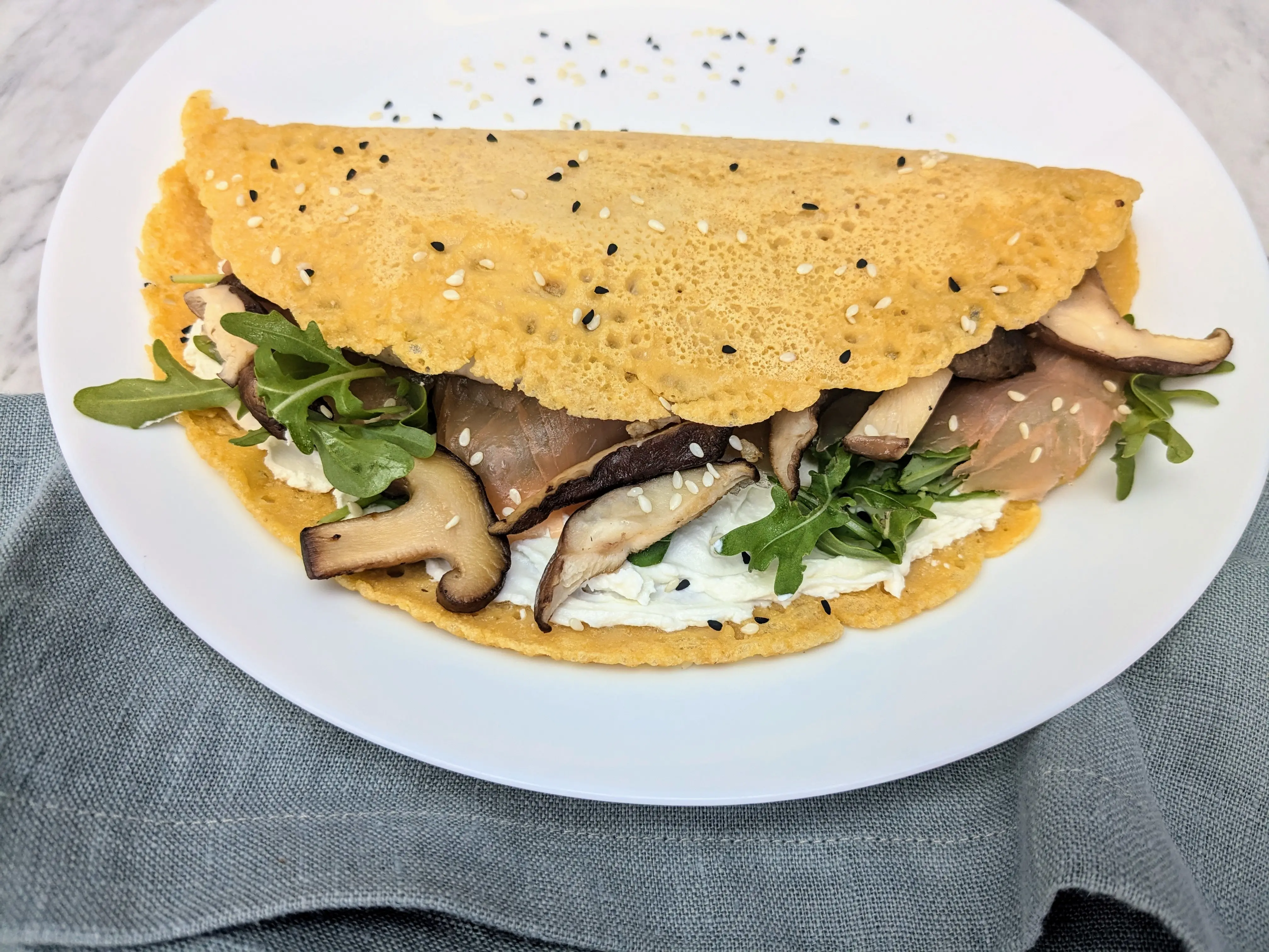 Socca (chickpea) pancakes with salmon, mushrooms and rocket