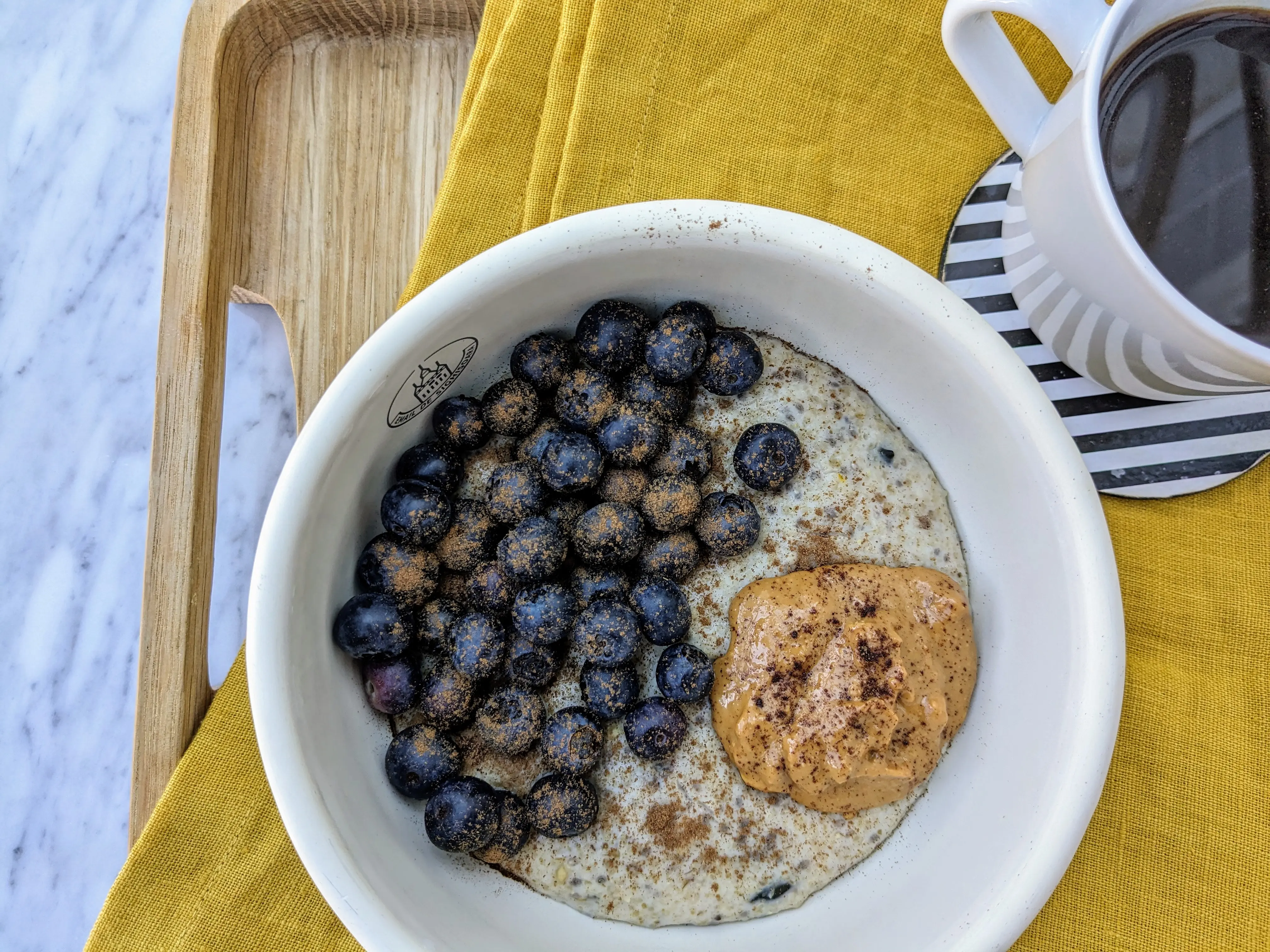 Vegan seedy oat bran porridge with peanut butter and blueberries