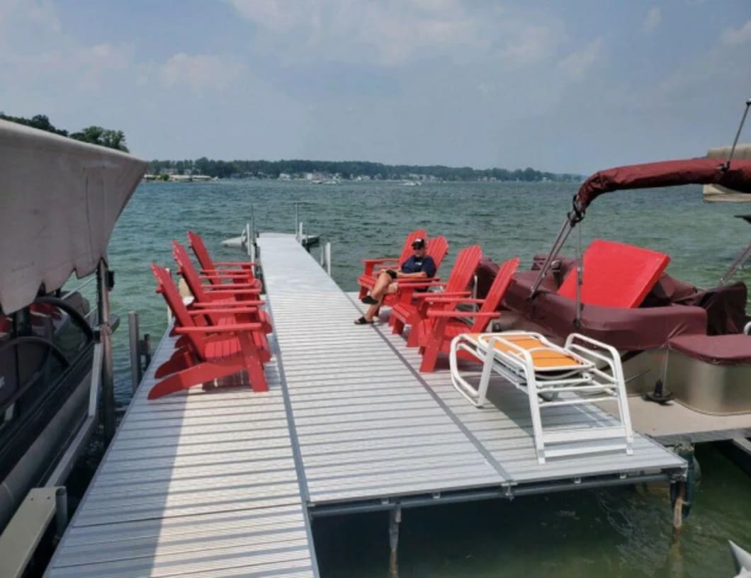 Aluminum dock with red chairs on the lake
