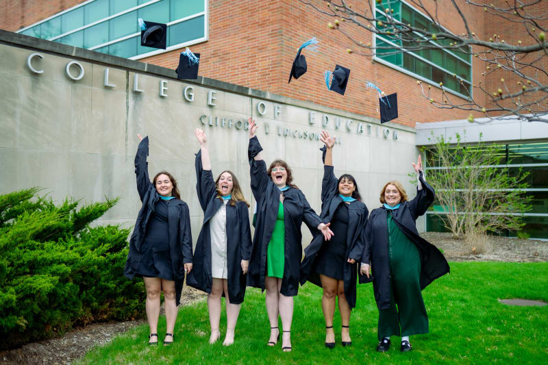 Group of MSU graduates tossing their caps