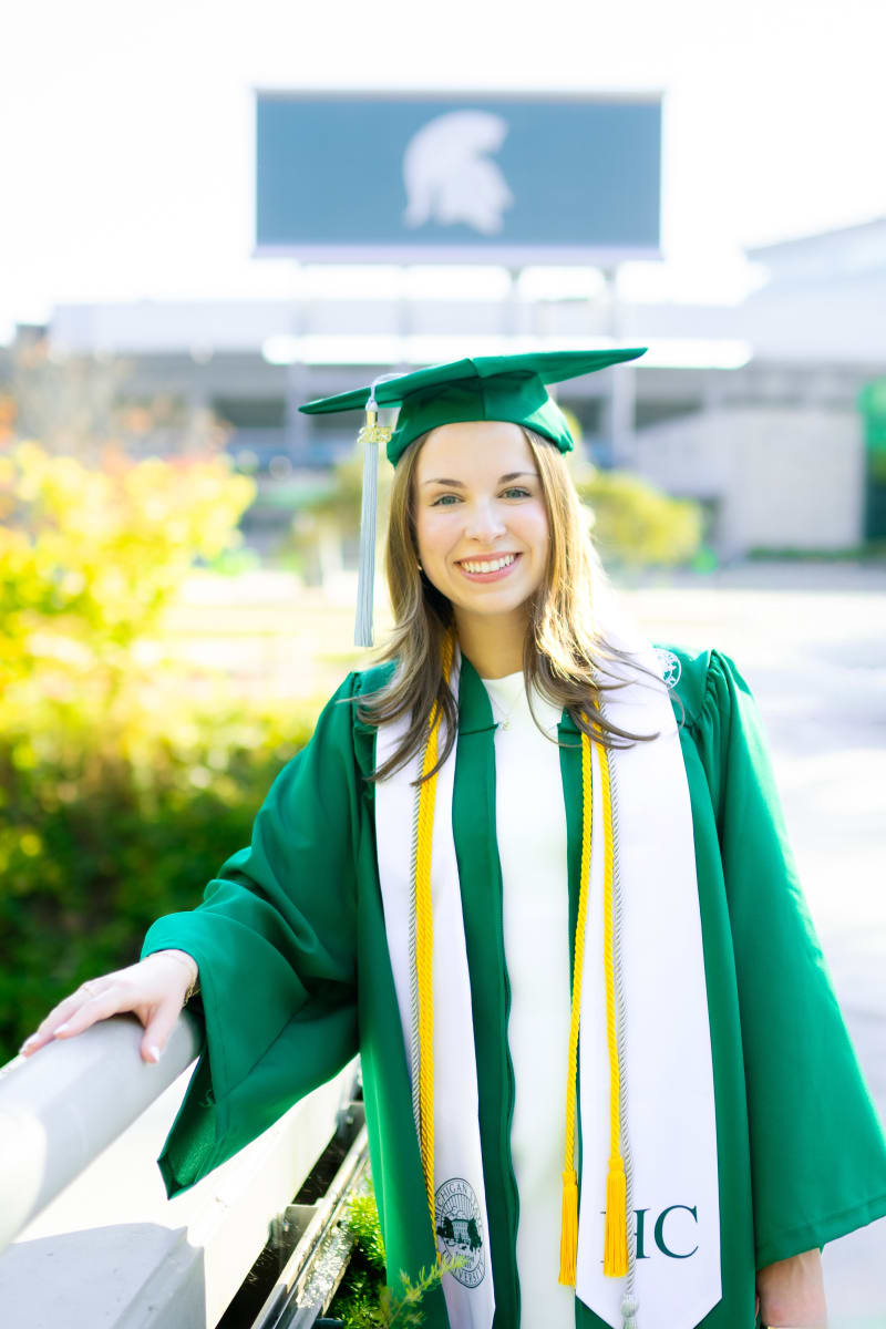 MSU graduate in cap and gown on campus