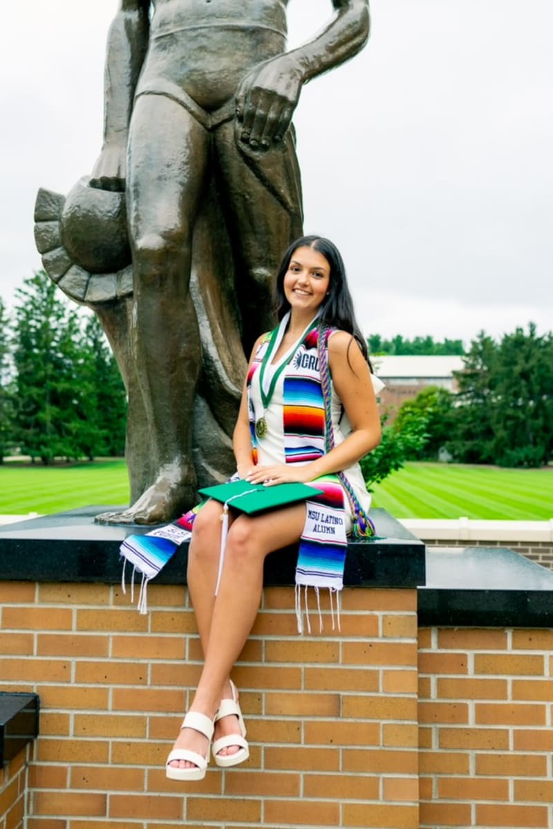 MSU graduate by the Spartan statue