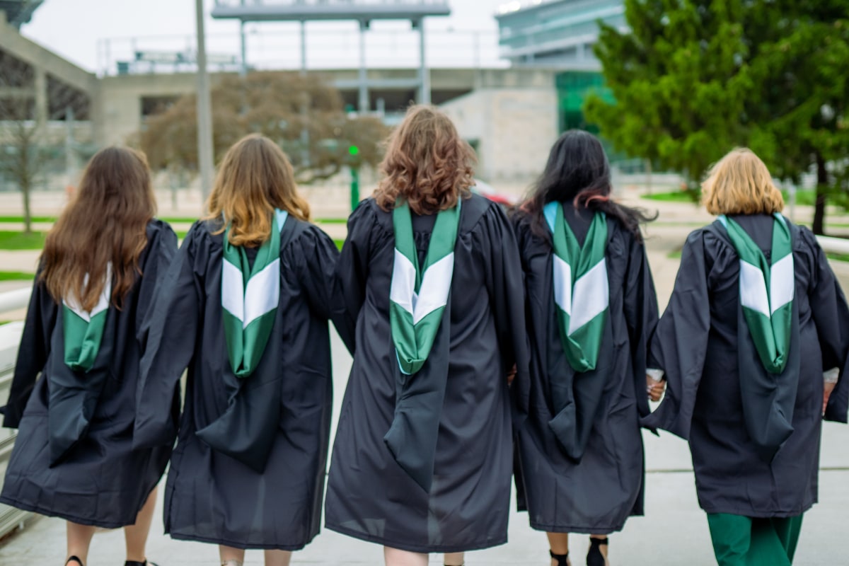 Graduates walking together in cap and gown