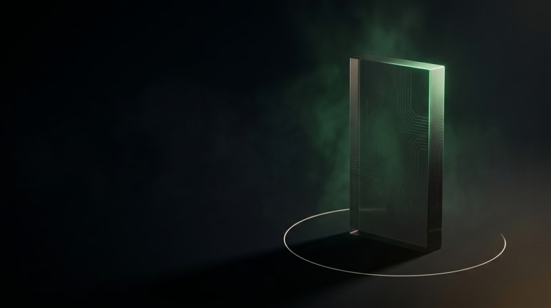 Monolito de cristal oscuro con luz verde emergente sobre fondo negro profundo, composición editorial cinematográfica