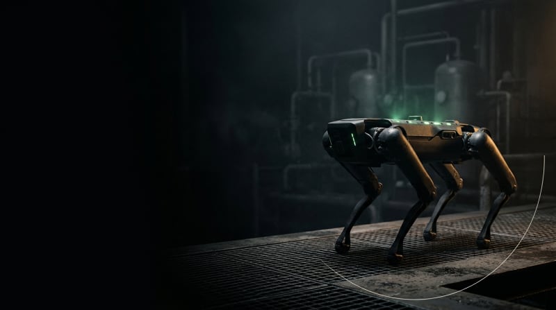Robot cuadrúpedo autónomo en entorno industrial oscuro con iluminación verde de sensores
