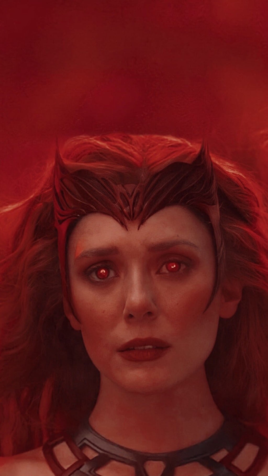 Portrait of woman with striking red hair, pointed features, and luminous red eyes against deep crimson background, dramatic a