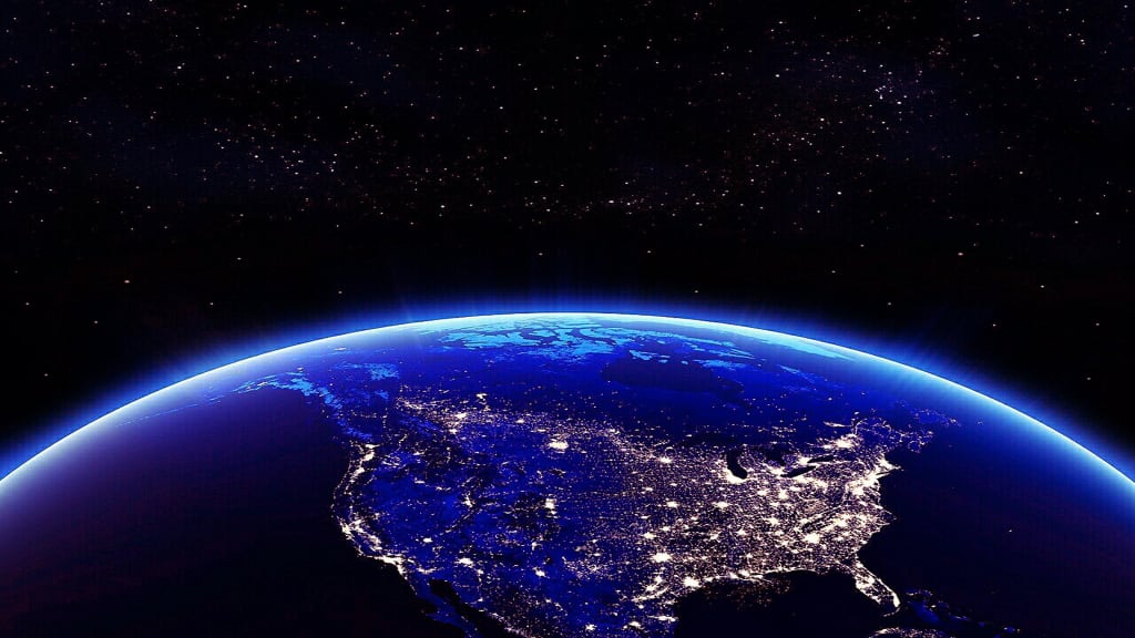 Earth glowing at night from space with city lights visible across continents, surrounded by starfield and atmospheric blue gl