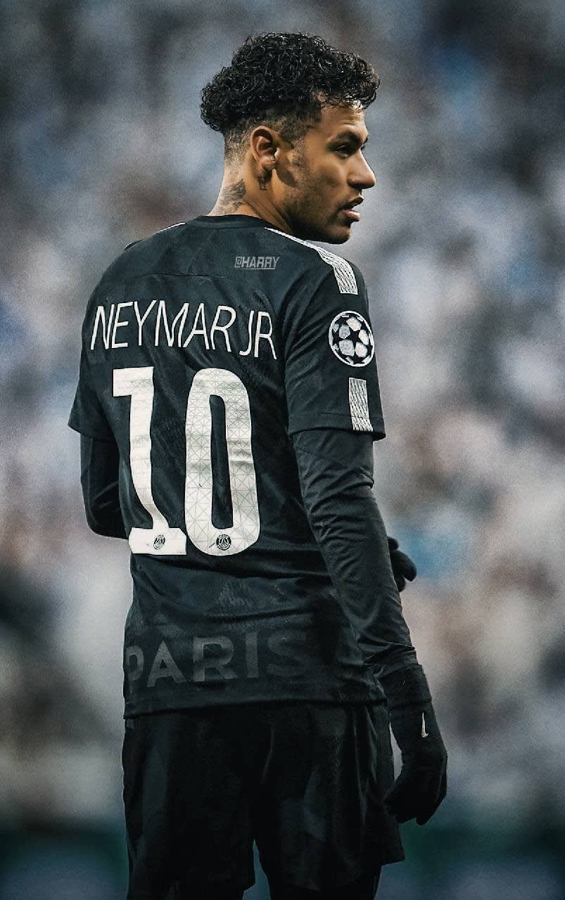 Professional footballer in black jersey number ten, shown in profile view during match, focused expression
