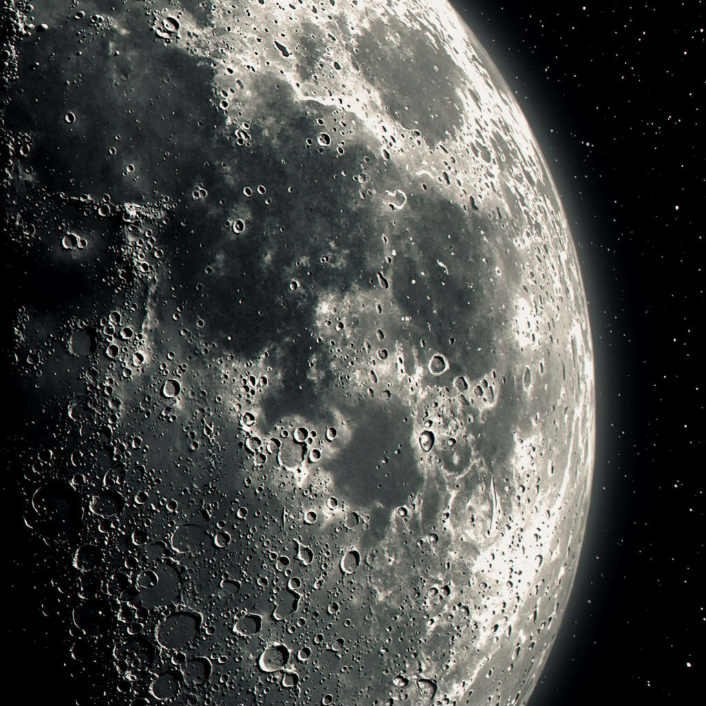 Detailed lunar surface showing numerous craters, ridges, and rocky terrain illuminated against black starry space background