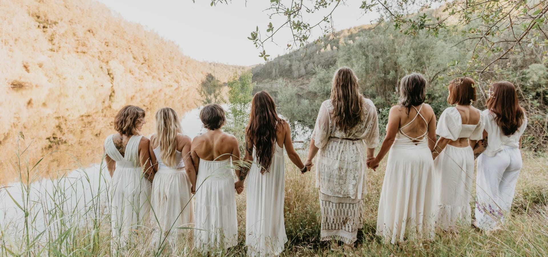 Women holding hands together at the river