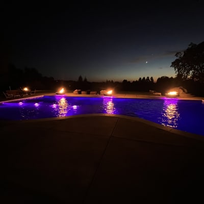 Pool with fire bowls purple lighting