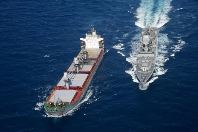 Indian Navy vessel patrolling near a commercial ship in the Arabian Sea amid maritime security operations.
