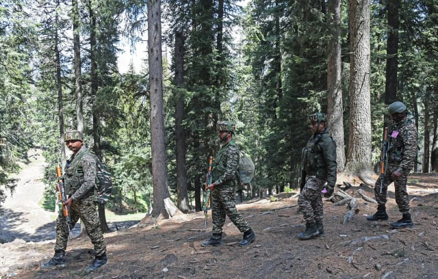 Indian Army and security forces conduct a search operation in a forested area of Jammu and Kashmir