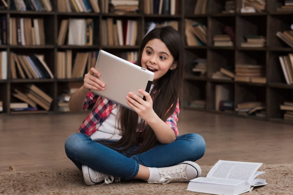 portrait-young-girl-playing-tablet-library