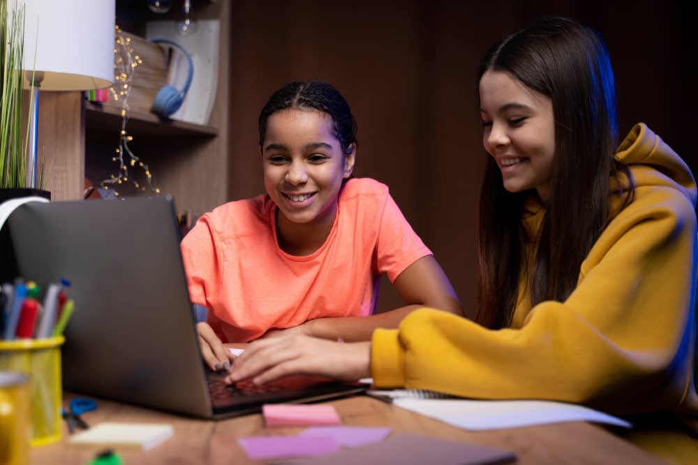 two-teenage-girls-studying-together-home-laptop