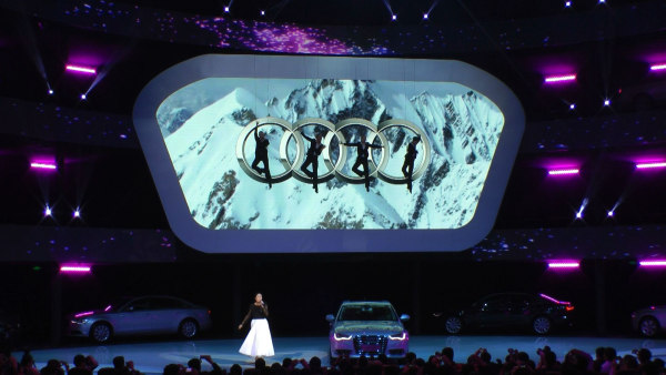 Vertical Dance Four people hanging in the air on winches, Audi Emblem between them 