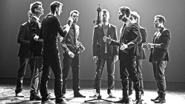 Acapella Group Eight men sing into a microphone