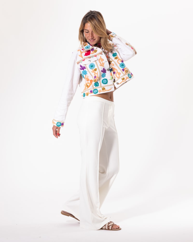 Blouson brodé blanc Licorne Passion porté avec pantalon large blanc, broderies multicolores florales