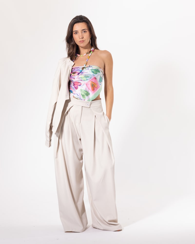 Pantalon large beige Licorne Passion porté avec un top fleuri, coupe wide leg à plis marqués et taille haute
