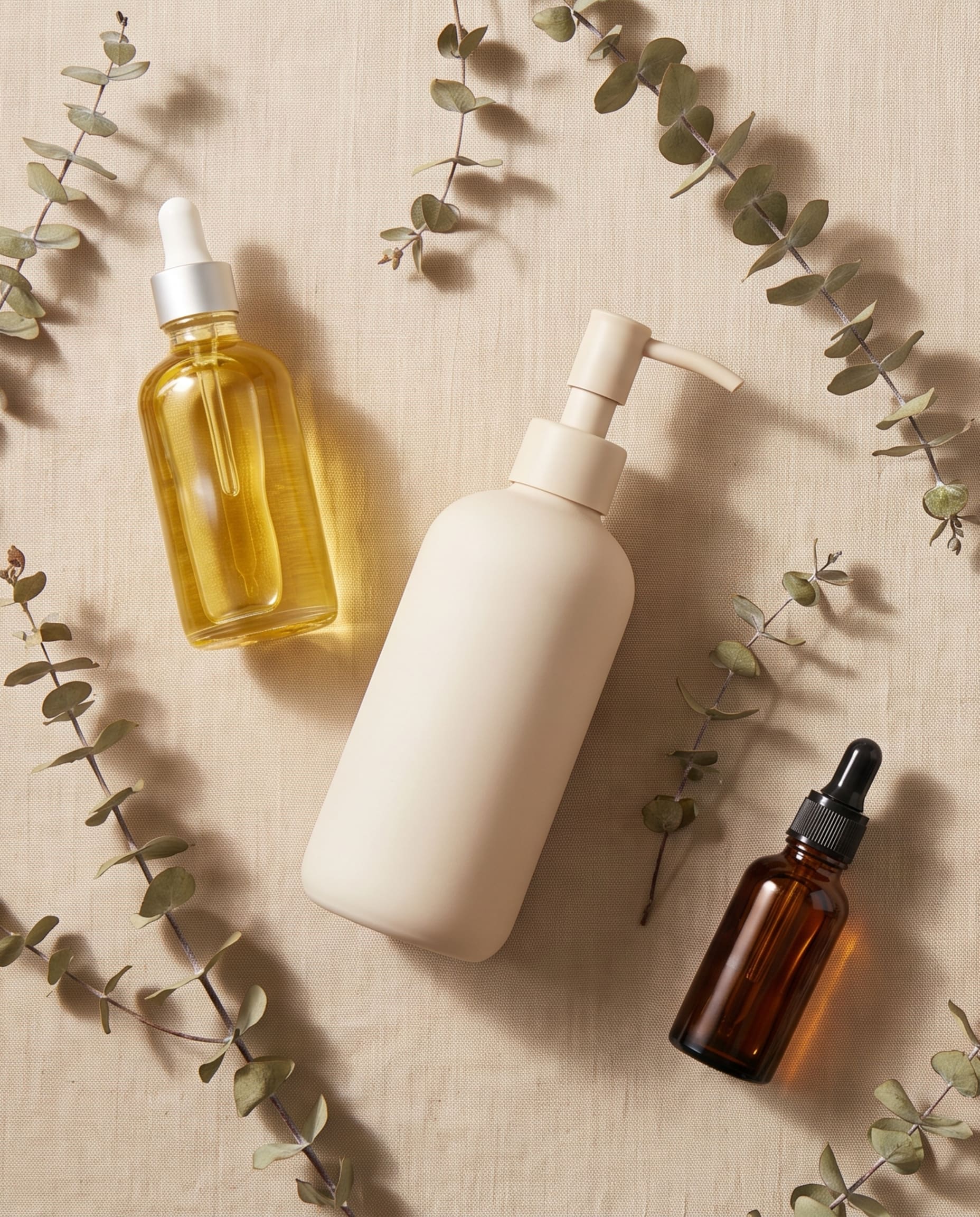 Aceites y tratamientos capilares de Licsy Cosmetics sobre fondo beige, composicion editorial.