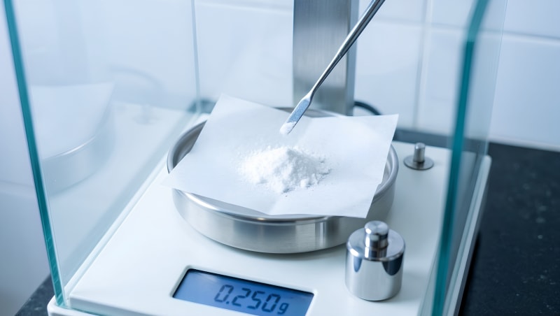 Balanza analítica de precisión pesando un activo cosmético en el laboratorio Tecnolabs