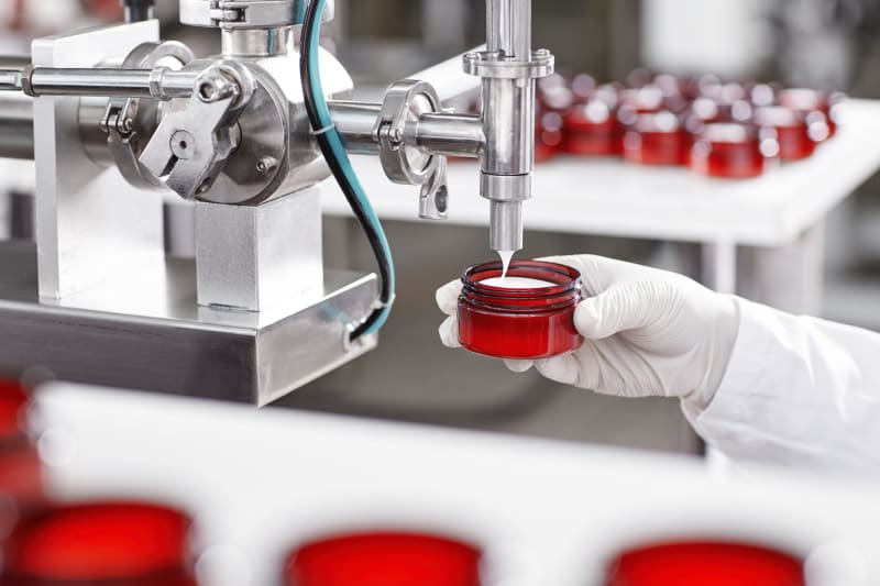 Llenado de crema cosmética en envase durante la maquila en Tecnolabs