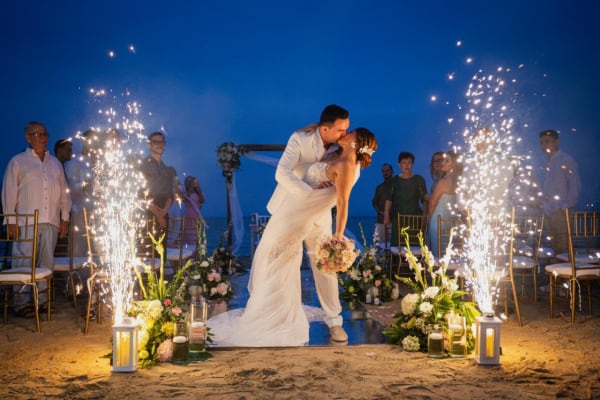 Newlyweds kissing with cold sparklers on the beach, real wedding at Villa Lotus Tolú