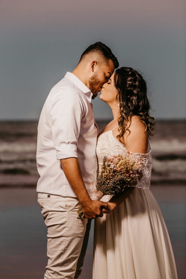 Pareja de novios besándose al atardecer en playa privada del Caribe colombiano, boda en Tolú Sucre