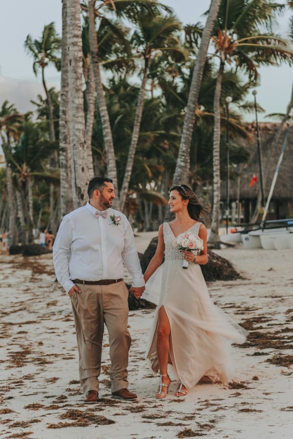 Novios caminando juntos en playa tropical del Caribe, boda destino en Lotus Beach House Tolú Colombia
