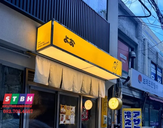 Bảng hiệu mica hiện đại cho cửa hàng — thiết kế gọn gàng, chữ rõ, phối màu hài hòa.