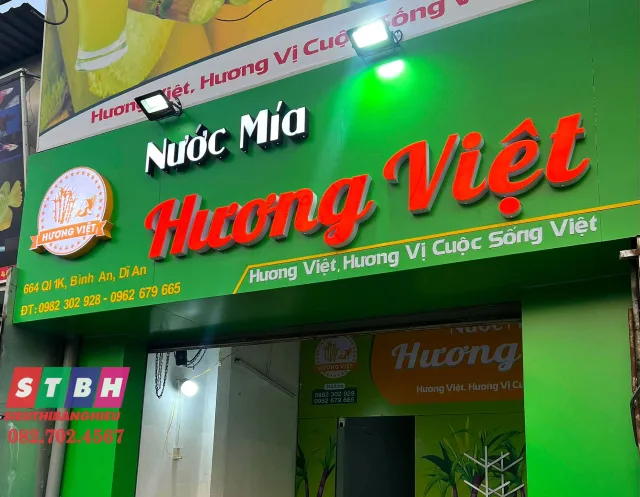 Bảng hiệu nước mía nổi bật với tông xanh và hình ly nước mía tươi mát.