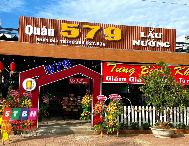 Bảng hiệu quán nướng với hình lửa và tông đỏ cam bắt mắt.