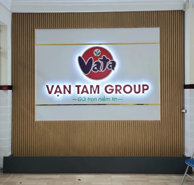 Logo nội thất Vạn Tâm Group mica hắt sáng chân tại sảnh