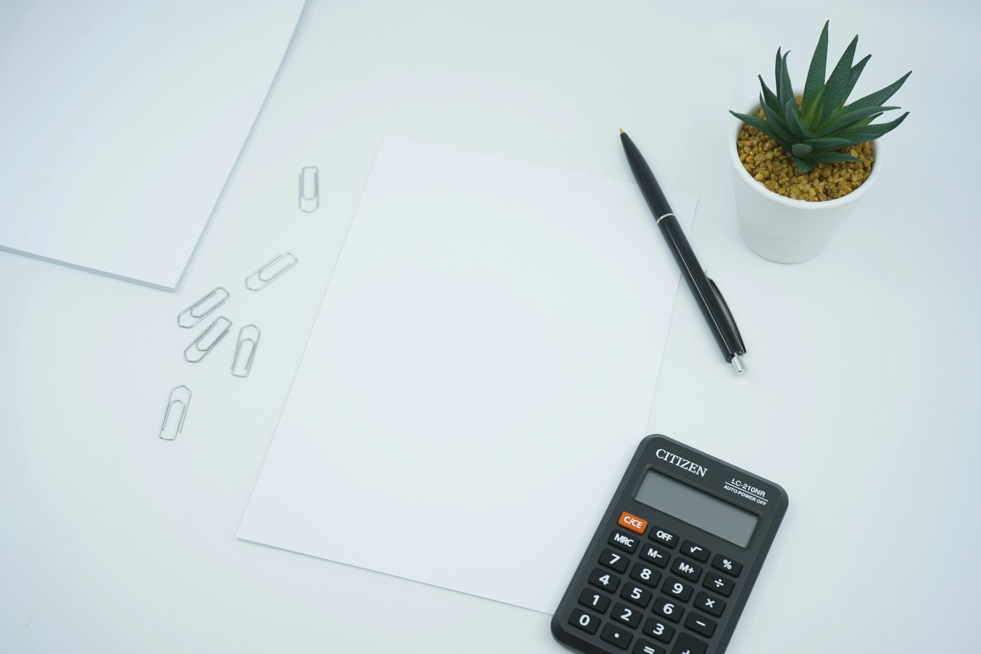 Bureau avec une calculatrice un crayon et une plante