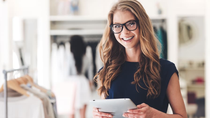 store clerk holding an iPad in clothing store