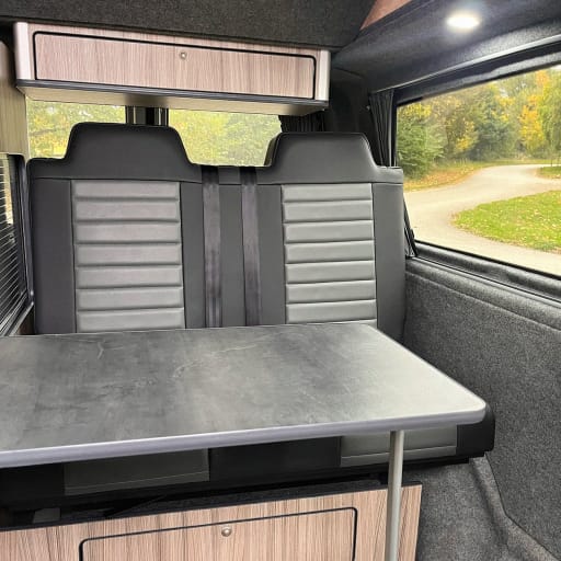 A fold out campervan table in from of the crash tested seats
