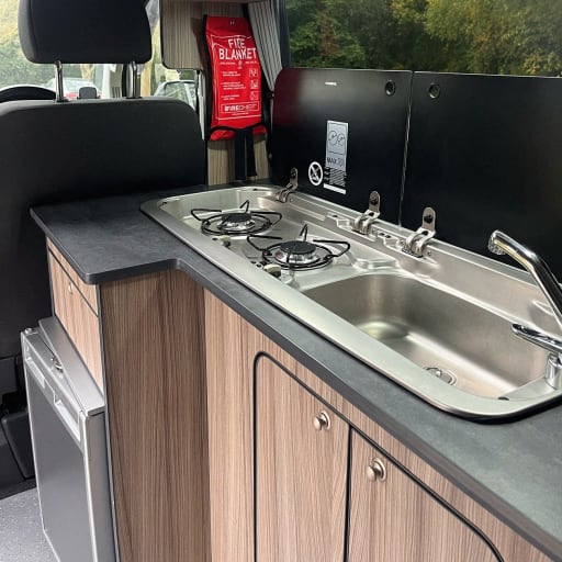 The campervan's 2-hob gas burner and sink