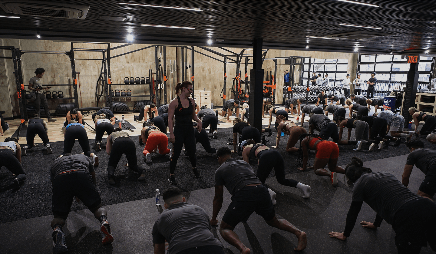 Hero image of a fitness coach training his client with kettlebells in a gym