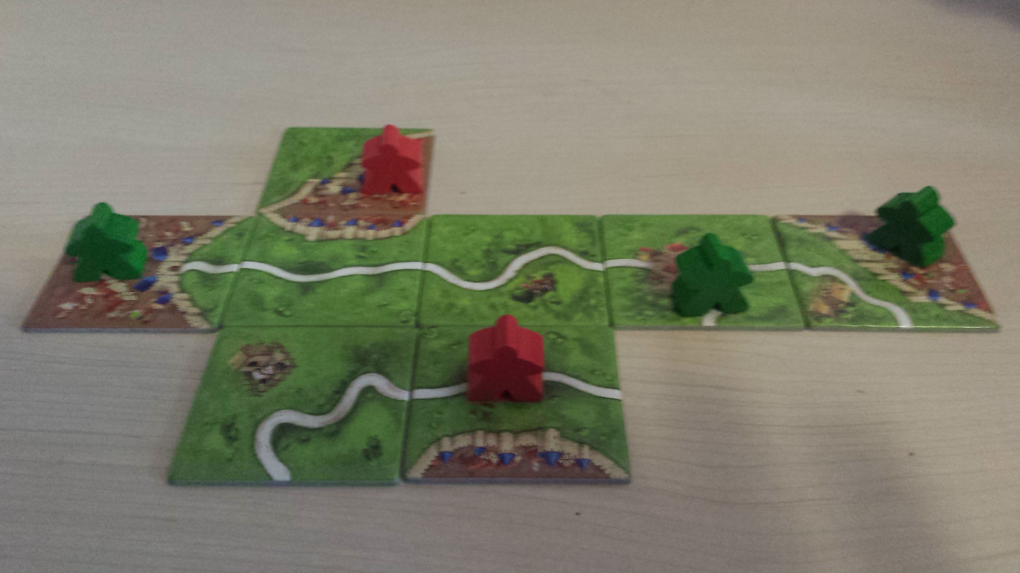 Carcassonne in progress A game of Carcassonne in progress with tiles and meeples on the table