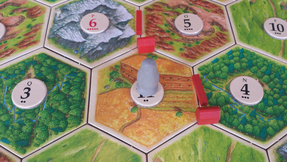 The robber in Catan The robber piece blocking a resource tile in Catan