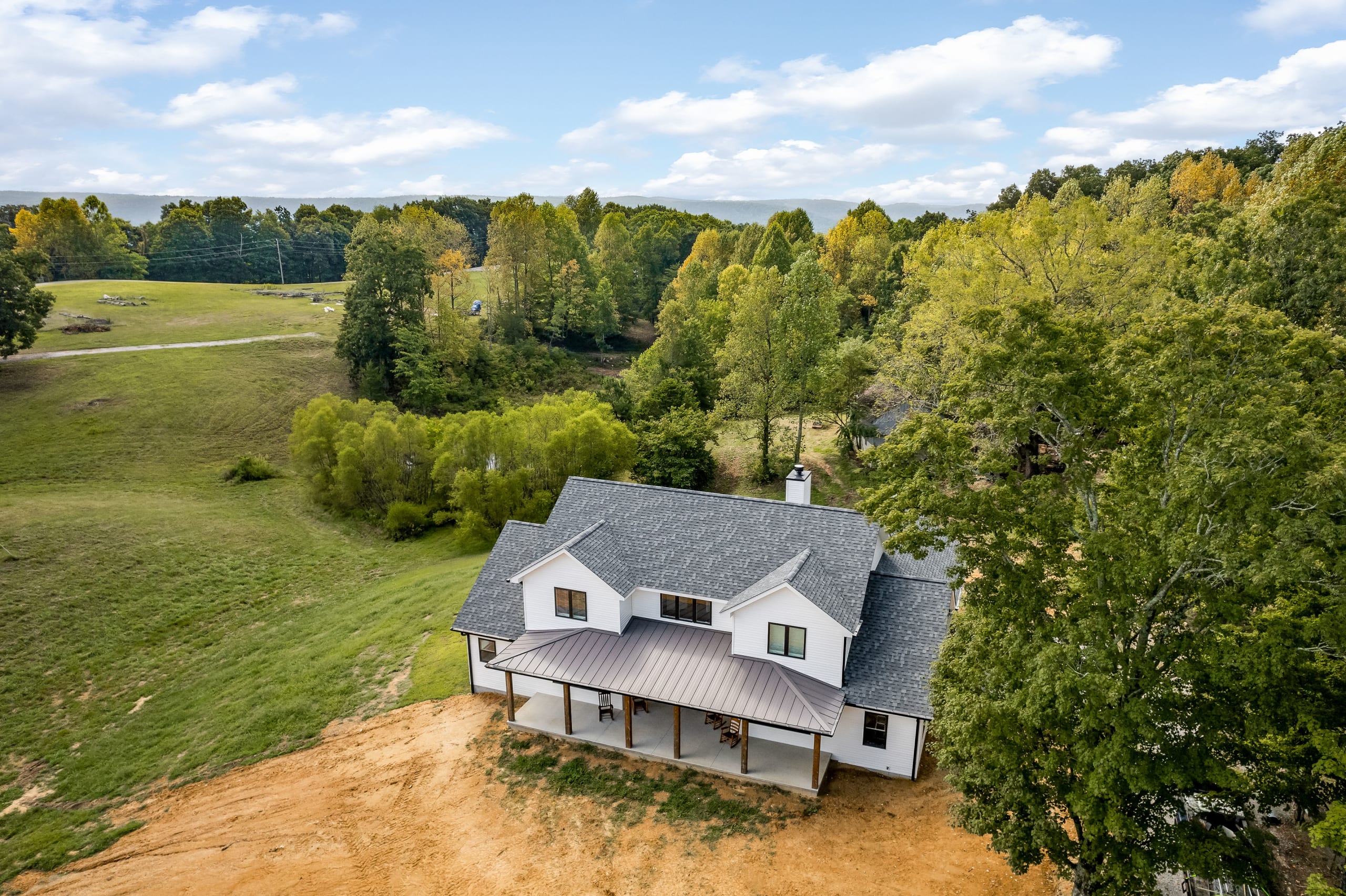 Panoramic view of covered porch highlighting farmhouse character and outdoor living space.