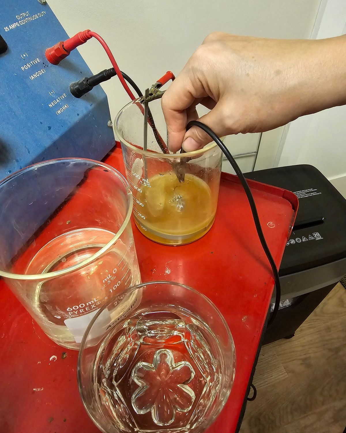 Gold electroplating chemical bath coating jewelry items in laboratory